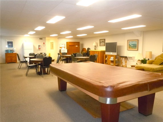 Room with pool table, seating area, and television.