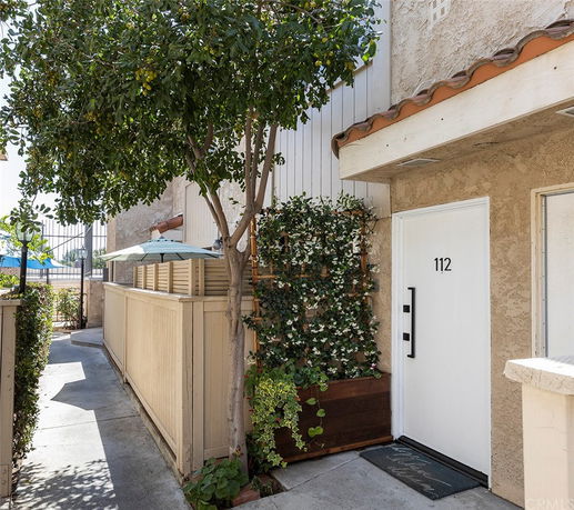 Front view of a house entrance with a white door numbered 112.