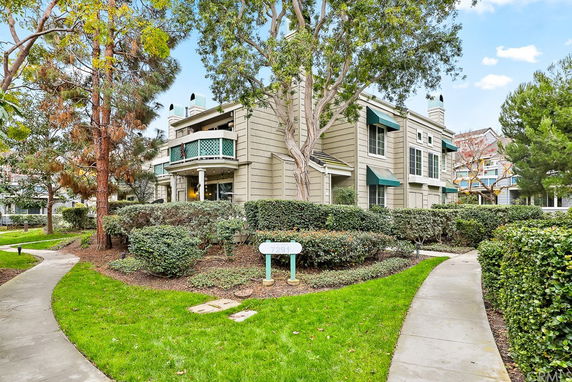 Front view of a multi-story building with a balcony and awnings.