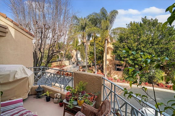 A balcony overlooking a street lined with trees and other buildings.