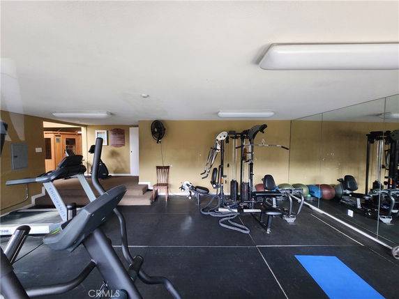 Indoor gym area with exercise machines and rubber flooring.