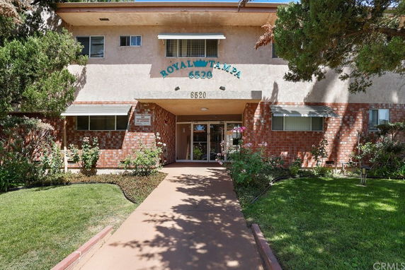 Front view of a multi-story building with a brick and stucco facade.