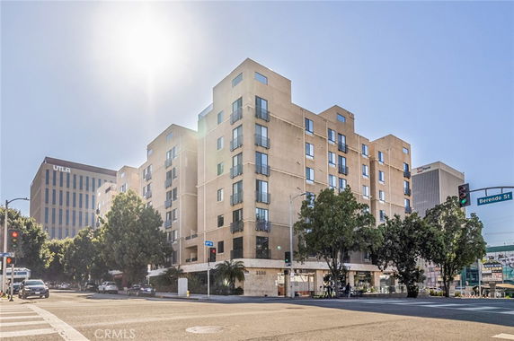 Front view of a multi-story apartment building at a street corner.