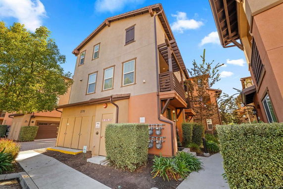 Front view of a three-story residential building with balconies.