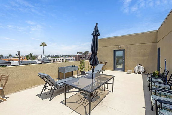 Rooftop with outdoor furniture and views of surrounding buildings.