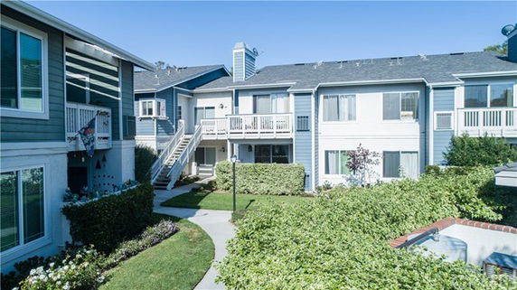 Front view of a multi-family residential building with balconies and a central courtyard.