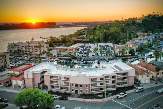 Panoramic view of residential buildings near a waterfront at sunset.