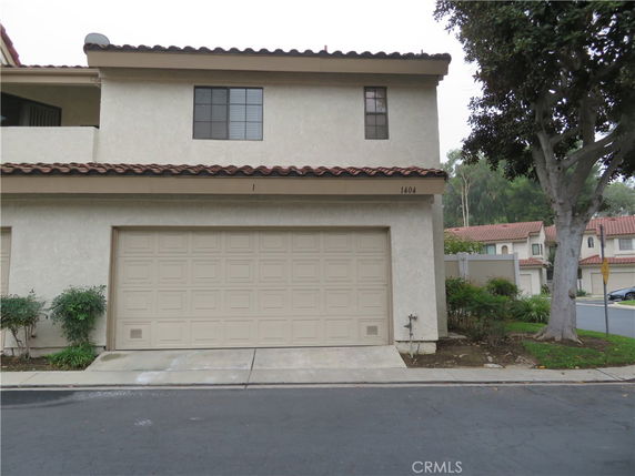 Front view of a two-story house with a double garage and a tiled roof.