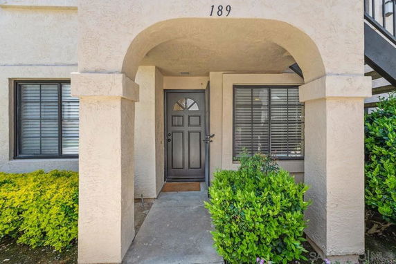 Front view of a house with an arched entrance and black front door.