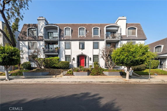 Front view of a multi-story residential building with balconies.