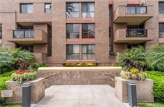 Front view of a multi-story brick building with balconies.