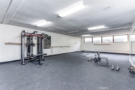 Interior view of a fitness center with gym equipment and weights.
