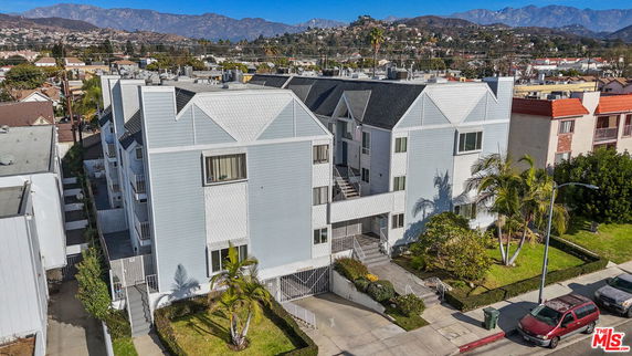 Front view of a multi-story residential building with modern design and multiple entrances.