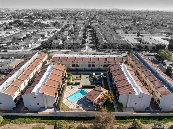 Aerial view of a multi-story residential complex with a central swimming pool and surrounding neighborhood.