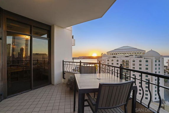 Balcony view of a cityscape at sunset with tall buildings.