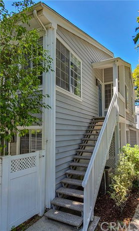 Exterior view of a two-story house with stairs leading to the entrance.
