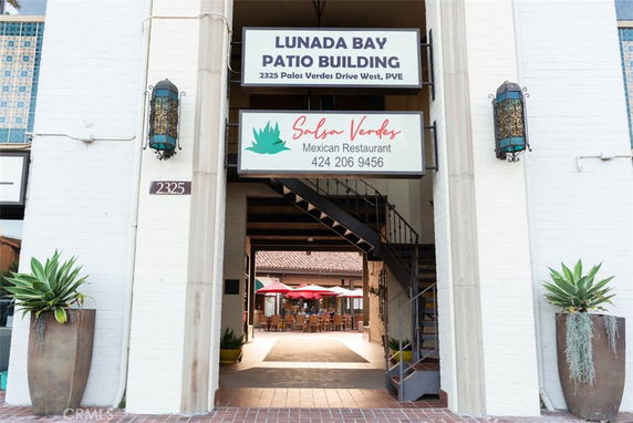 Front view of a building entrance with signs for Lunada Bay Patio Building and a Mexican restaurant.