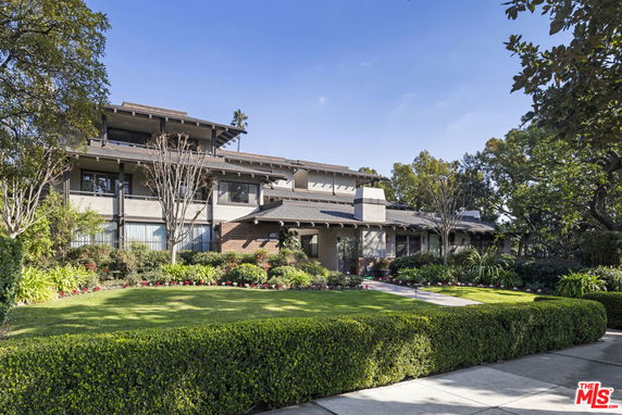 Front view of a multi-story house with landscaped garden.