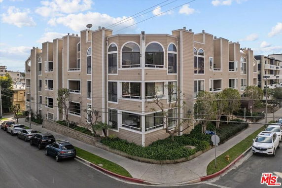 Front view of a multi-story apartment building with large windows and a modern design.