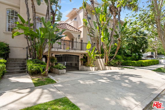 Front view of a multi-story house with a balcony and garage.