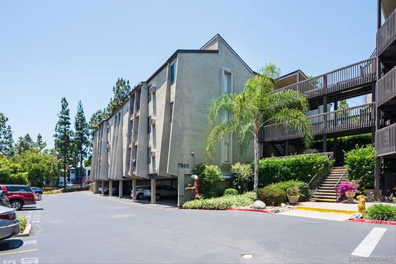 Front view of a multi-story building with an open parking area underneath.