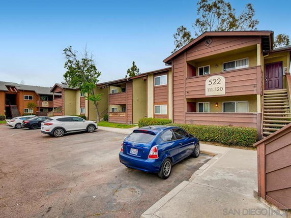 Front view of an apartment building with adjacent parking lot.