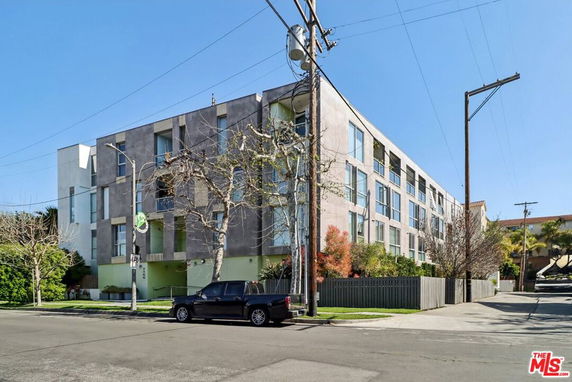 Front view of a multi-story residential building with large windows.