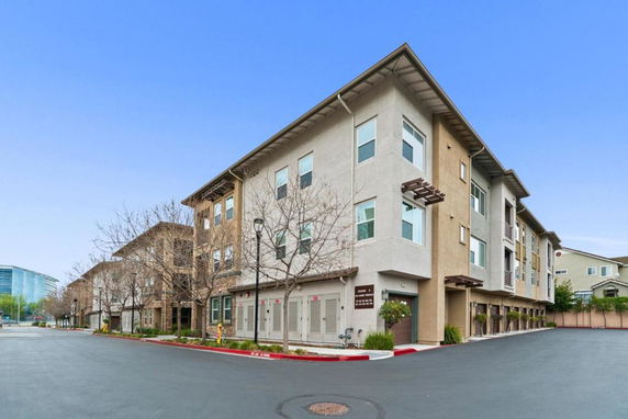 Front view of a multi-story apartment building with multiple windows and entrances.