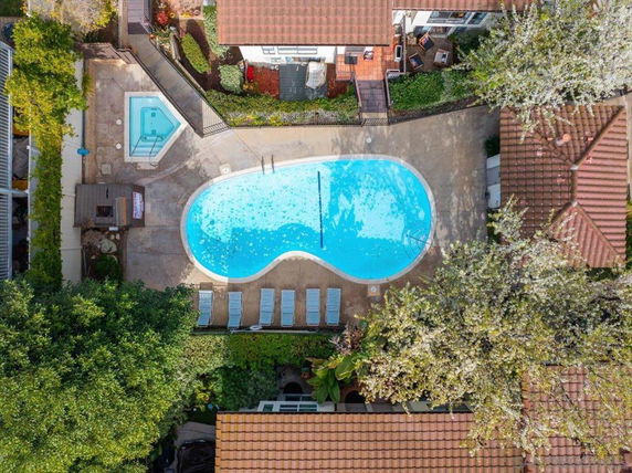 Aerial view of a swimming pool surrounded by houses and trees.
