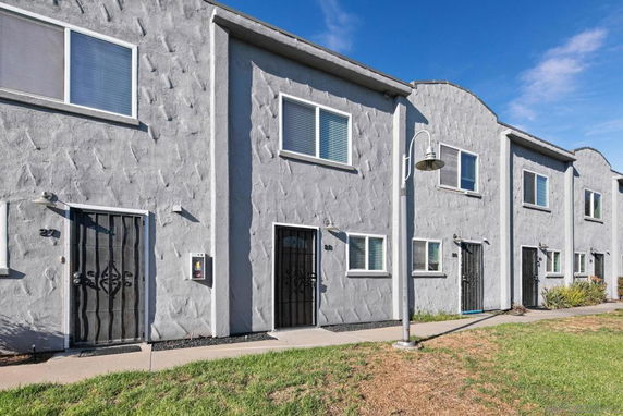 Front view of a two-story building with multiple units and textured gray exterior.