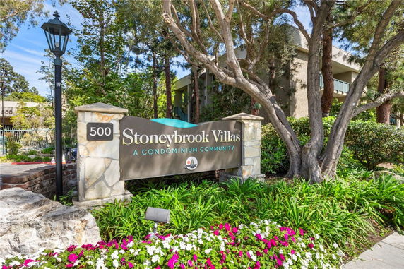 Front view of a condominium community entrance with a sign reading 'Stoneybrook Villas'.