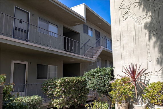 Front view of a multi-story apartment building with exterior corridors.