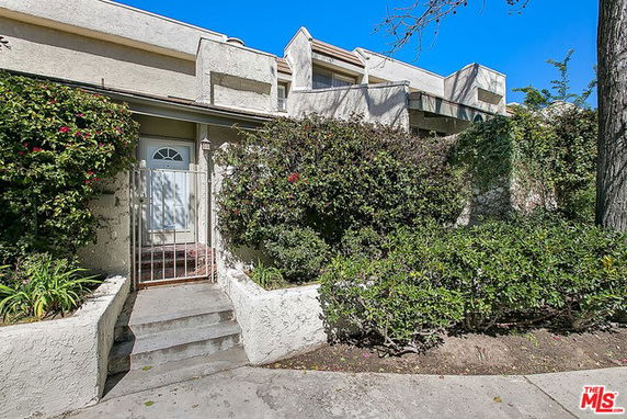 Front view of a two-story townhouse with a small gated entrance.