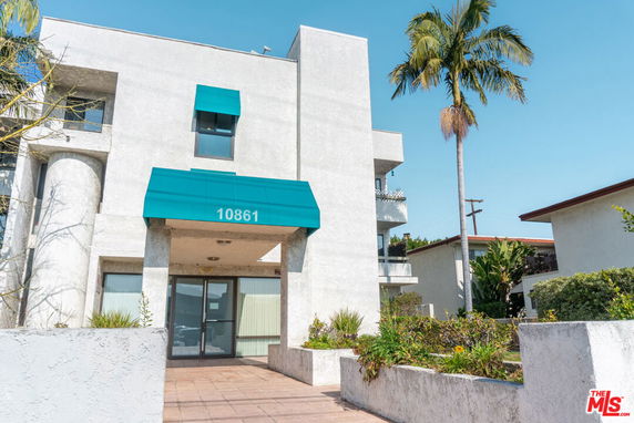 Front view of a multi-story building with an entrance awning.