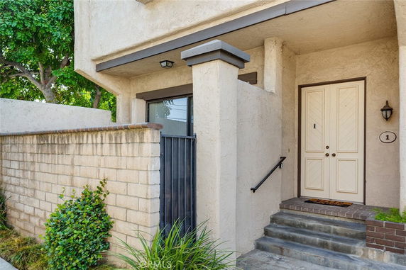 Front view of a house entrance with steps and a double door.