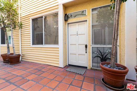 Front view of a residential entrance with a white door and adjacent windows.