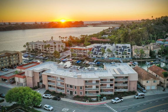 Panoramic view of residential buildings near a waterfront at sunset.