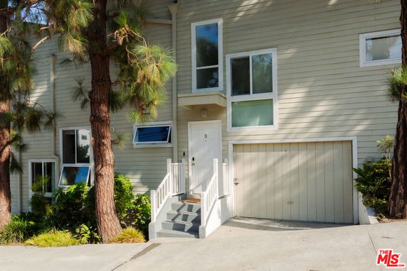 Front view of a house with an attached garage and a small staircase leading to the entrance.