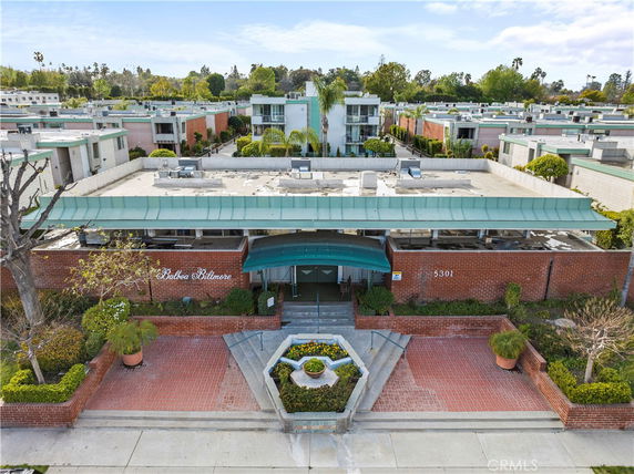 Front view of a large multi-story building with a flat roof and red brick exterior.