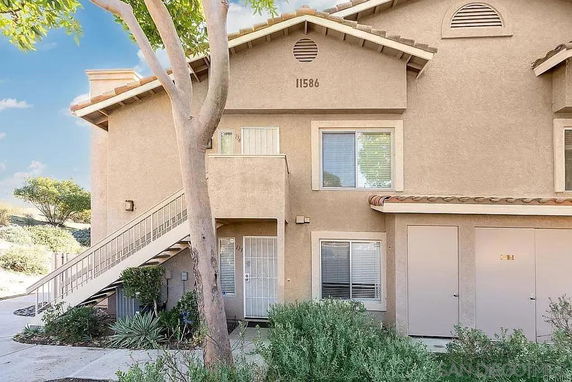 Front view of a two-story building with stairs leading to the upper floor.