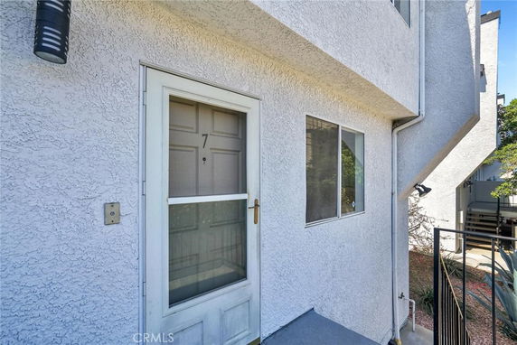Front view of a building entrance with a numbered door and a window.