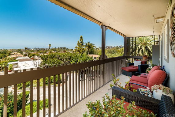 Balcony view overlooking trees and distant landscape.