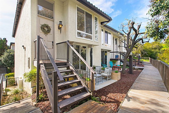 Front view of a multi-story house with a staircase leading to the entrance.