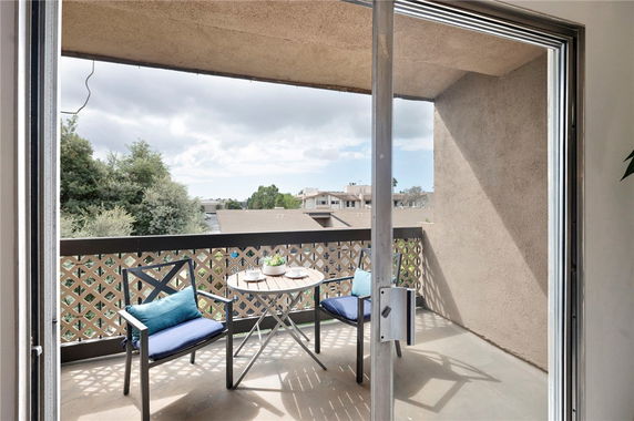 Balcony view overlooking neighboring buildings and trees.
