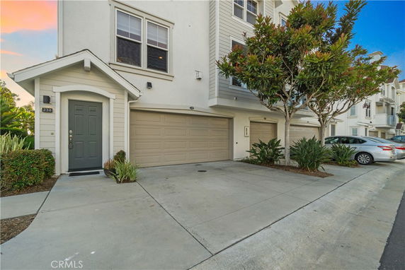 Front view of a multi-story house with garage and driveway.