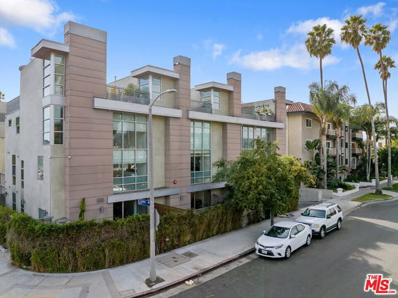 Front view of a modern multi-story building with large windows and flat roof.