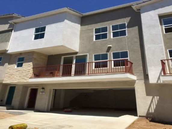 Front view of a multi-story house with attached garage and balcony.