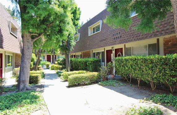 Front view of townhouses with brick and shingle exterior.