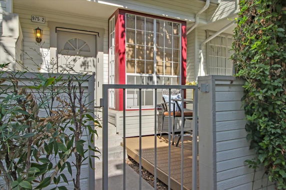 Front view of a house with a gated entrance and a small porch area.
