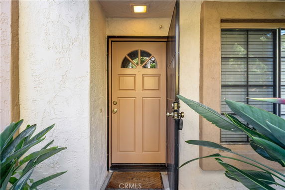 Front view of a house entrance with a solid door and adjacent window.